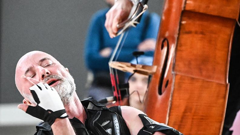 Un homme qui danse à coté il y a une contrebasse