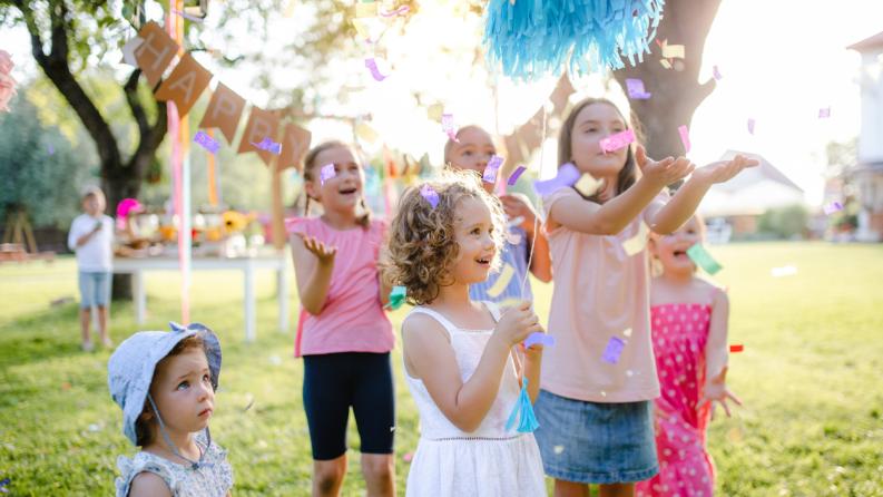 Petits enfants restant à l’extérieur dans le jardin en été, jouant