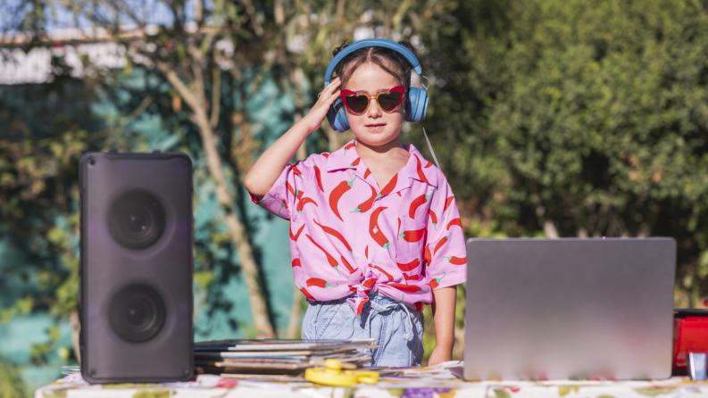 Petite fille qui fait le DJ lors d’une fête estivale en plein air
