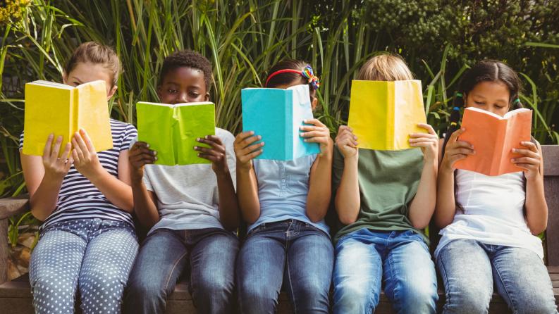 Enfants lisent des livres dans le parc
