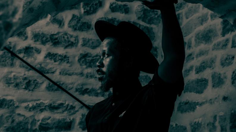 Un homme est photographié de profil et il porte un chapeau