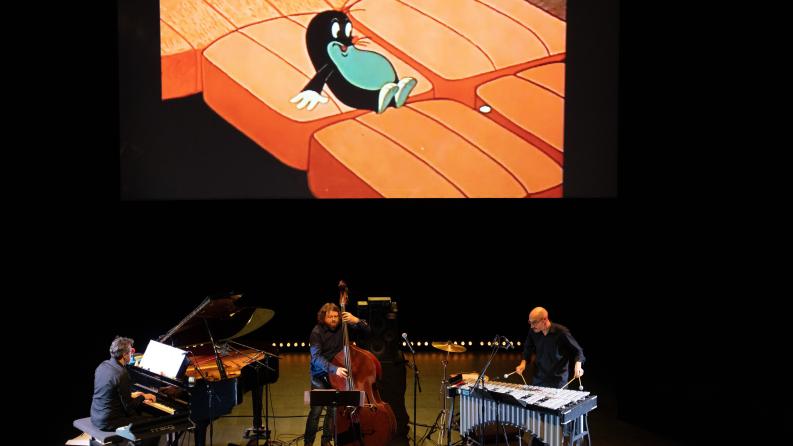 Des musiciens sur scène avec une projection de dessin animé