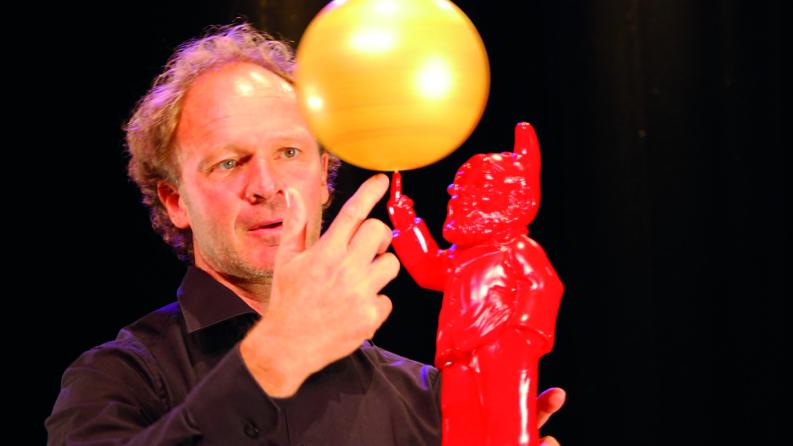 Un homme fait tourner un ballon sur son doigt
