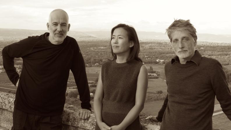 Un groupes d'artistes, une femme et deux hommes posent en pleine nature