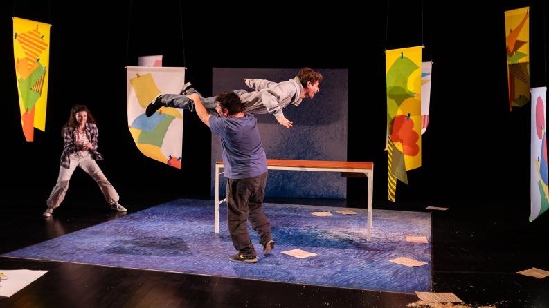 Un homme en tient un autre sur son épaule sur une scène de spectacle