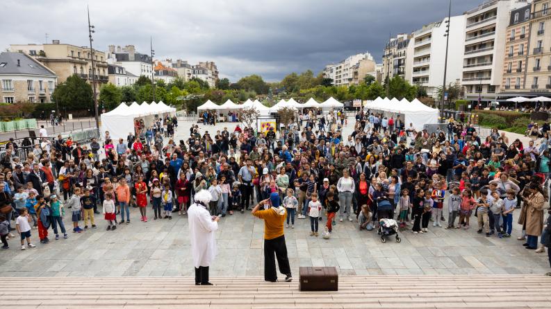 on y voit une foule regroupée écoutant la consigne d'une personne