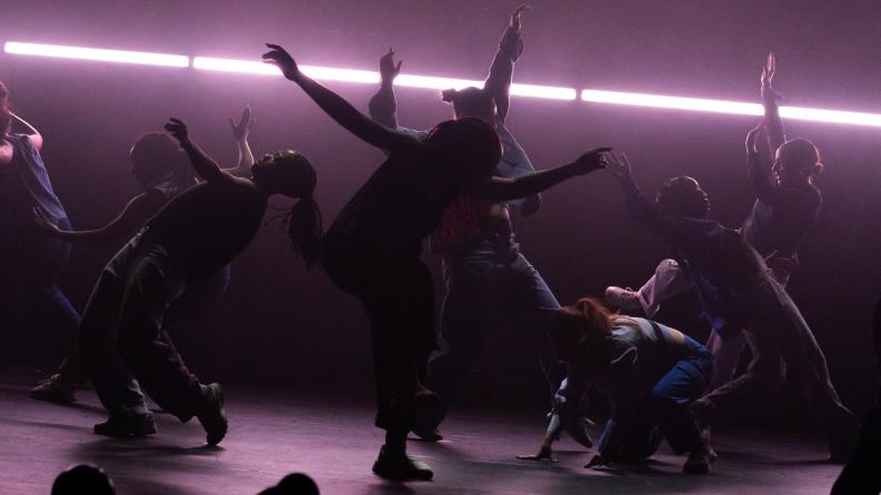 Un groupe de danseurs dans une lumière tamisée 