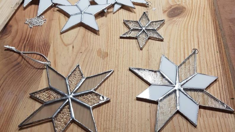 Des vitraux en forme d'étoile posées sur une table en vous 