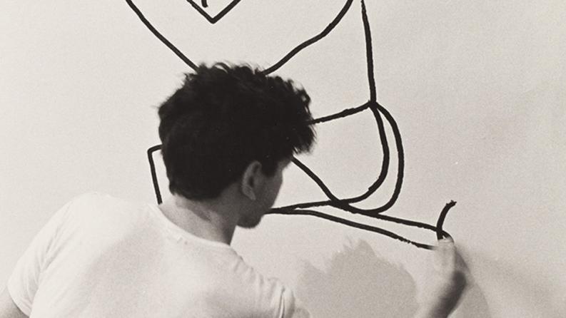 un jeune homme dessine sur un mur