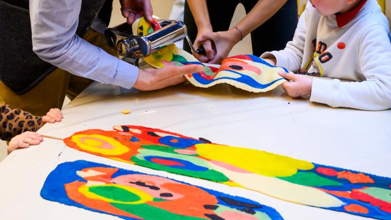 Des personnes regardes des affiches colorées posées sur une table