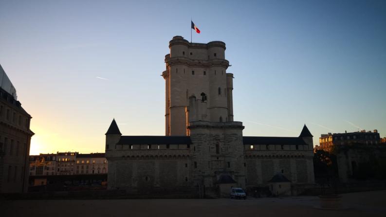 une photo du château de vincennes au moment du couché du soleil