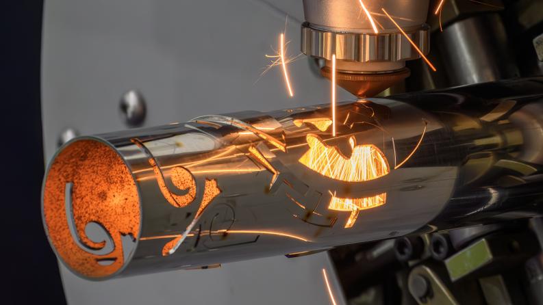Scène rapprochée de la machine de découpe laser à fibre a coupé le tube en acier inoxydable et la lumière étincelante.