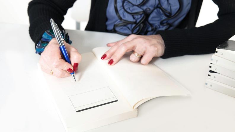 Une femme dédicace un livre
