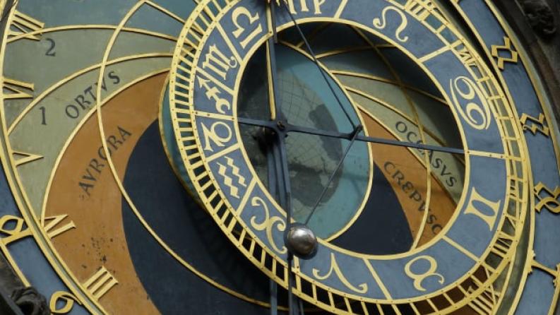Une photo d'une horloge avec les signes du zodiak