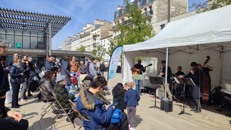 Un groupe de musique joue devant une foule rassemblée sur une place de Vincennes.