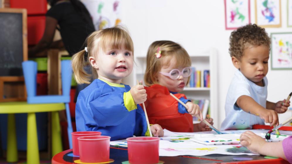 enfants qui jouent sur une table et colorient