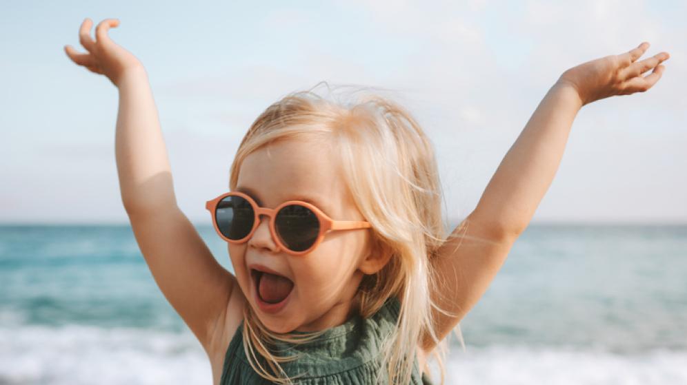 Drôle d’enfant fille jouant en plein air surpris enfant émotionnel dans des lunettes de soleil 3 ans bébé levé mains vacances en famille