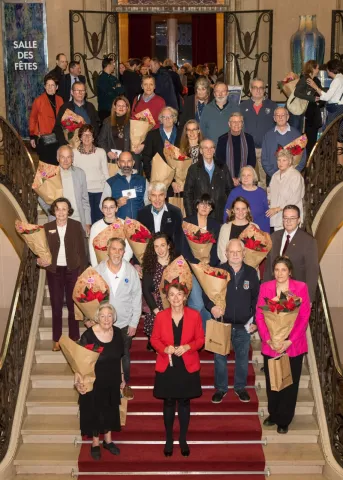 Photo des bénévoles avec le maire dans les escaliers de l'hotel de ville