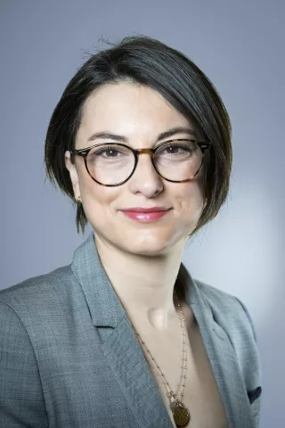 Une femme aux cheveux court sourit à l'écran