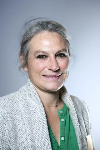 Une femme qui sourit en regardant l'objectif