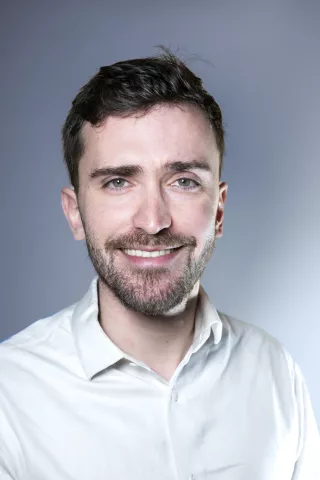 Un jeune homme sourit à l'objectif