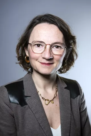 Une femme brune regarde l'objectif en souriant