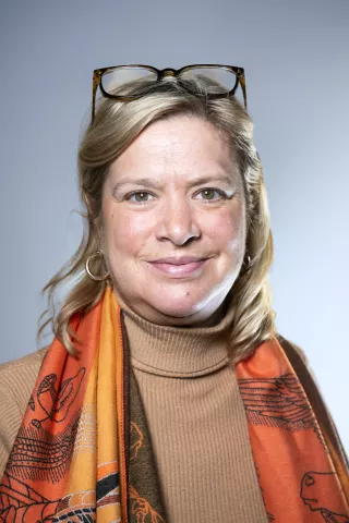 Une femme brune sourit à l'objectif