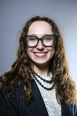 Une jeune fille au cheveux bouclé sourit à l'objectif