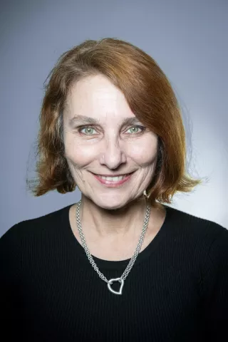 Une femme rousse sourit à l'objectif 